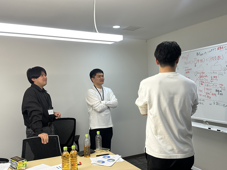 ホワイトボードを前に課題に真剣に取り組む